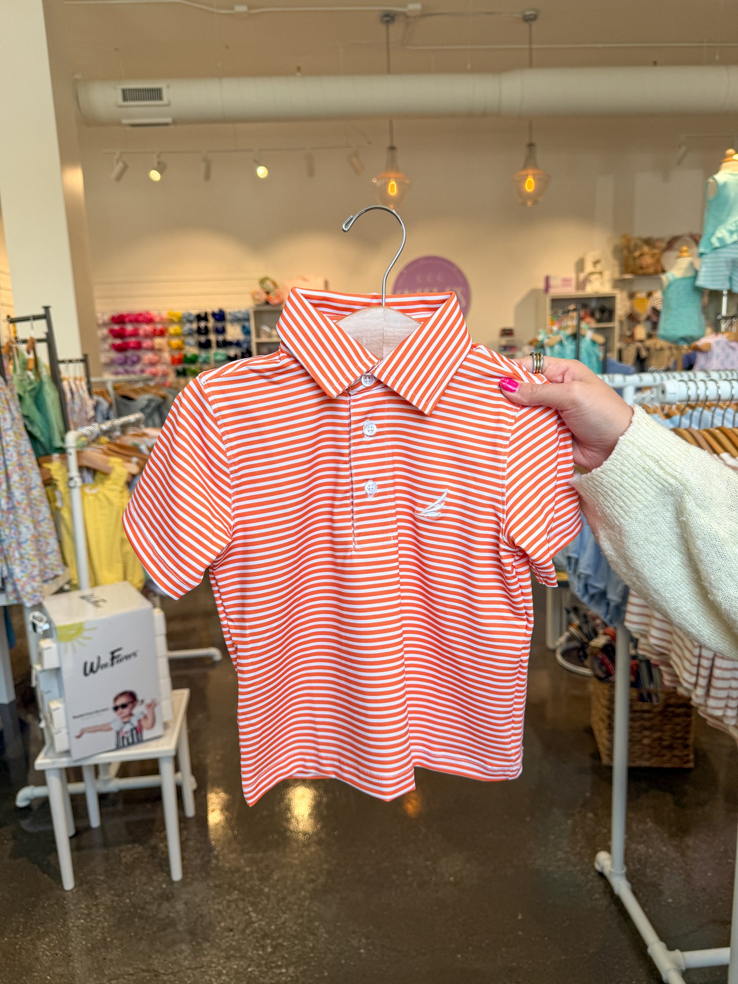Orange and white striped Brooks Performance short-sleeve polo shirt by Coolybri showing a close-up of the fabric and collar.