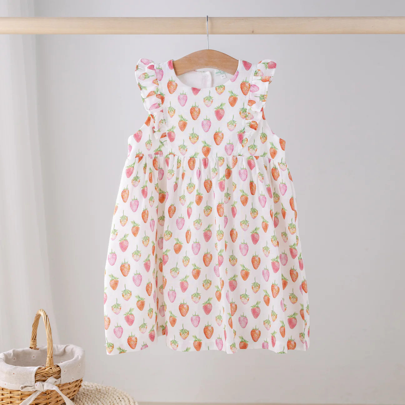 Nola Tawk Berry Cute Organic Muslin Dress for babies, soft pastel pink with floral print and ruffled sleeves, front view.