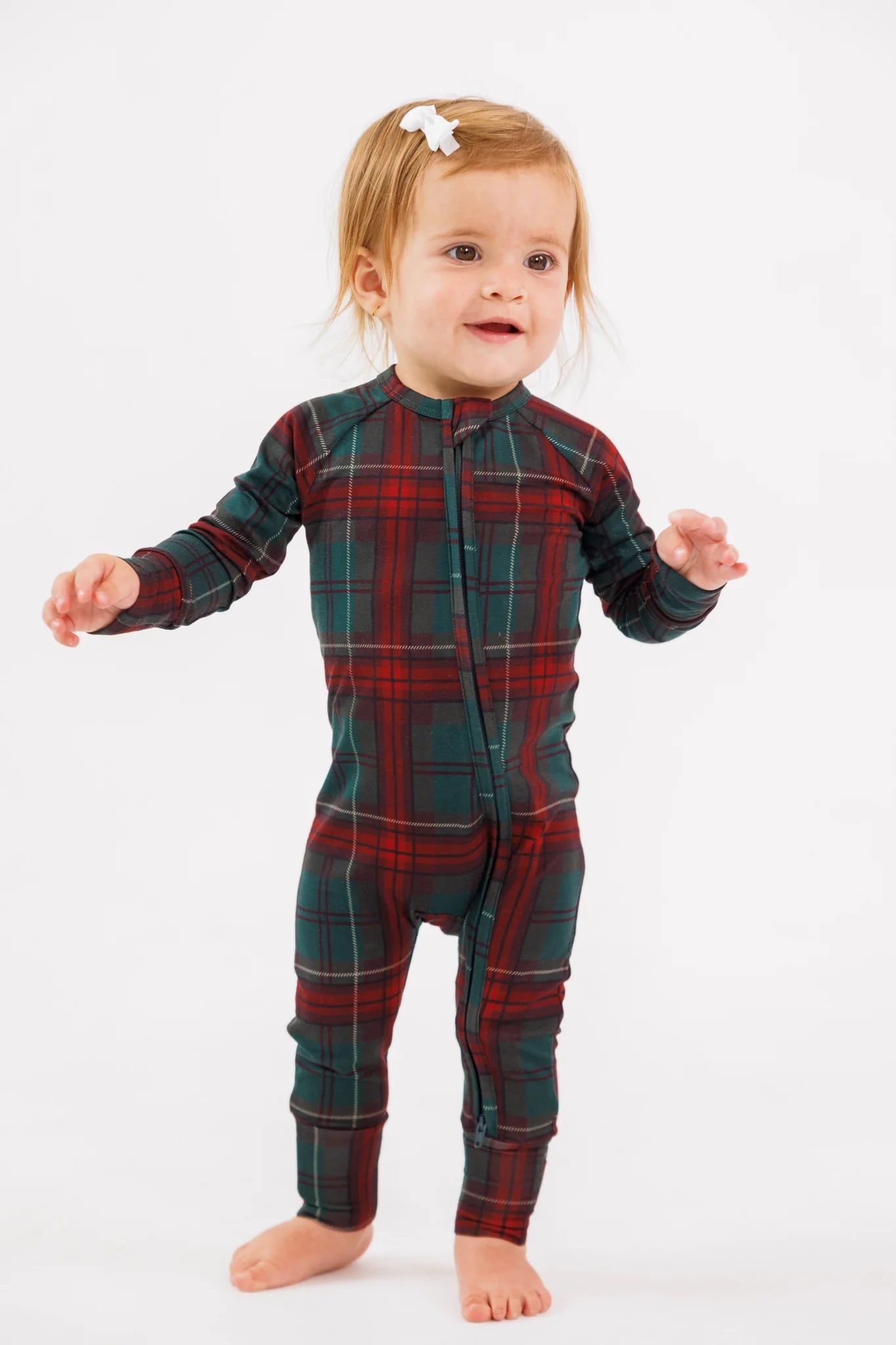 In My Jammers Holiday Heritage plaid zipper romper, featuring festive red and green plaid fabric with a front zipper and long sleeves.