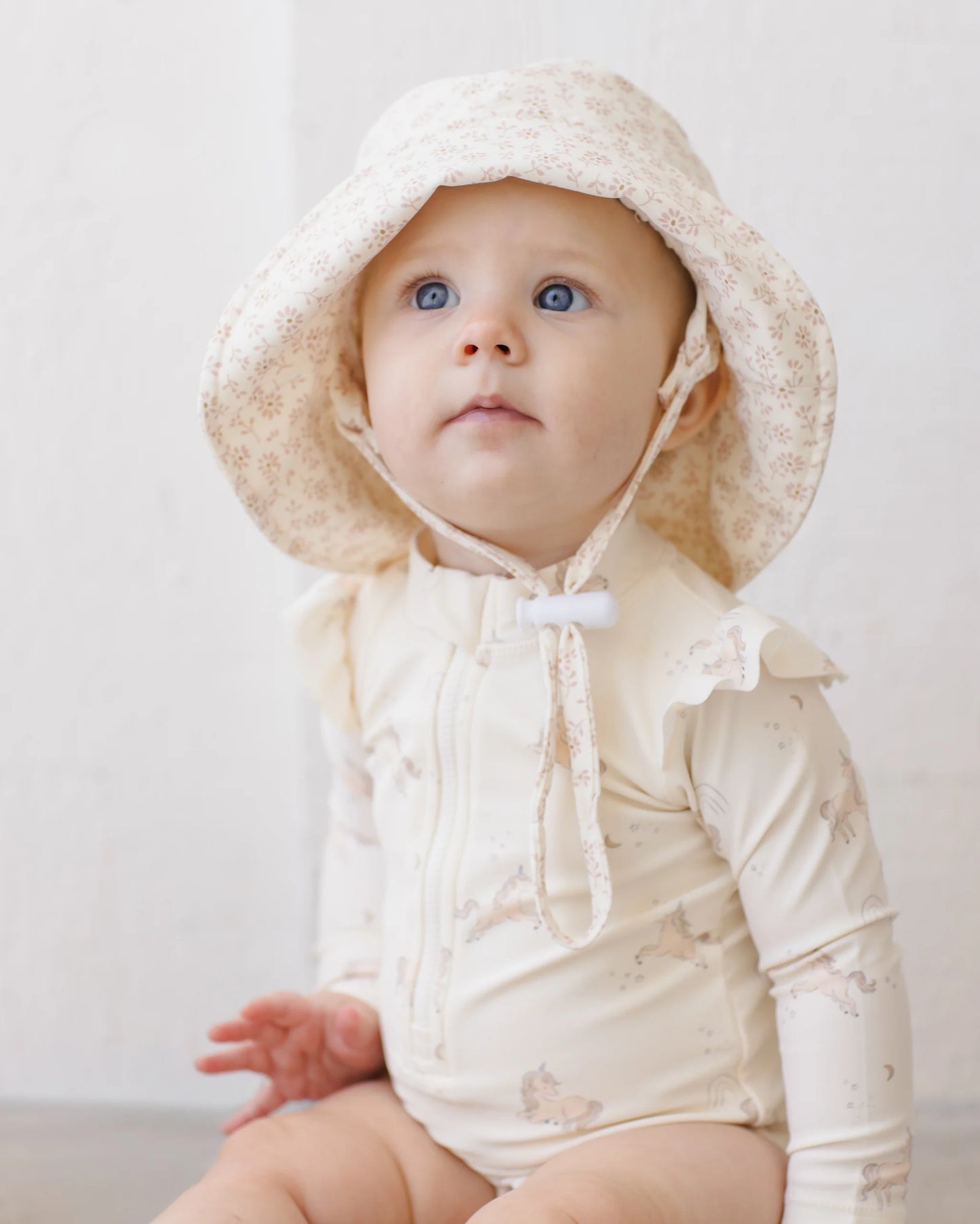 Quincy Mae Ditsy Bucket Hat in a soft, patterned fabric, shown outdoors with a casual, relaxed style.