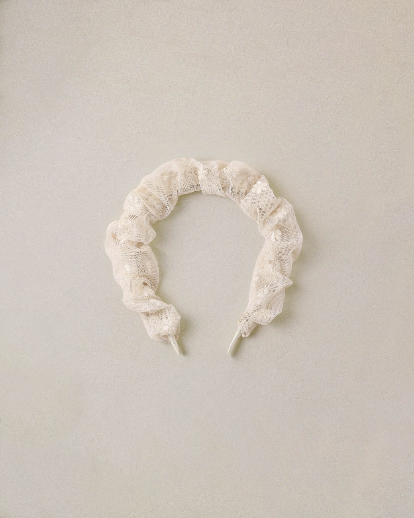 Noralee embroidered daisy gathered headband with floral design, featuring intricate embroidery and soft fabric for a stylish accessory.