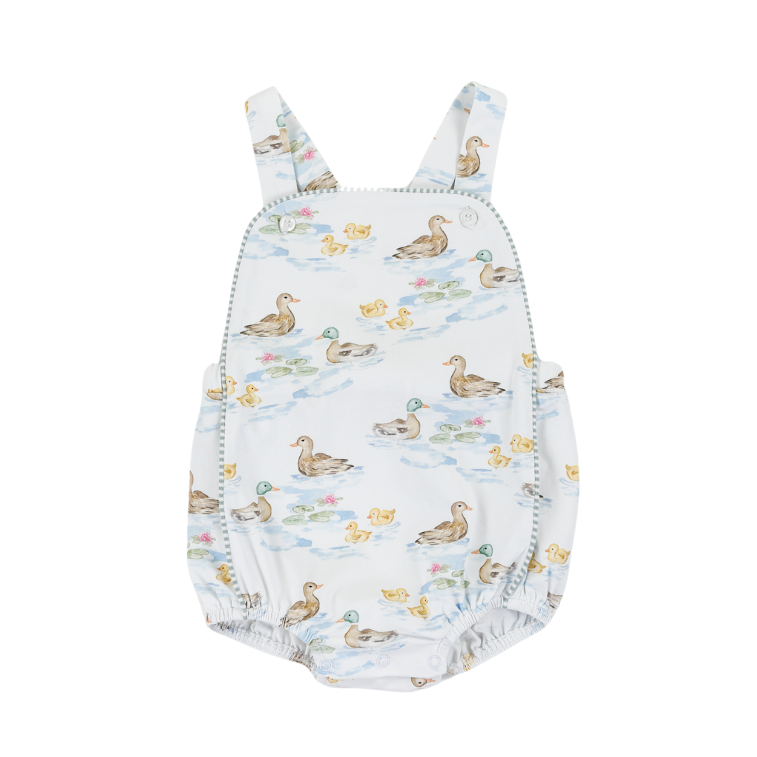 Baby girl wearing a Darling Ducks Silas Sunsuit by Cypress Row, featuring colorful duck prints and lightweight fabric.