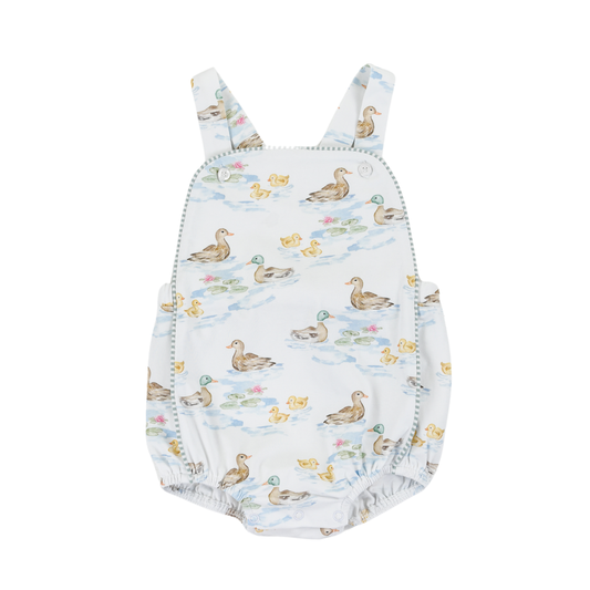 Baby girl wearing a Darling Ducks Silas Sunsuit by Cypress Row, featuring colorful duck prints and lightweight fabric.
