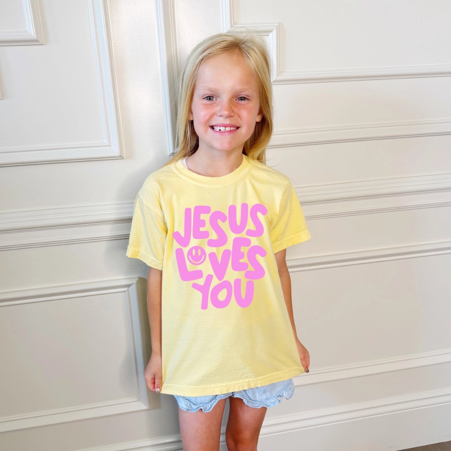 Smiley Jesus Loves You Puff Youth Tee by Poppy & Pine featuring a colorful Jesus love graphic on a casual youth t-shirt