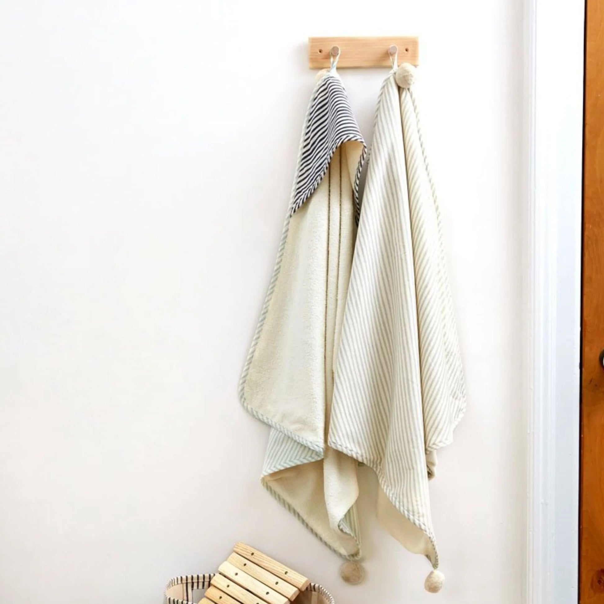 Pehr Stripes Away Sea hooded towel with colorful striped pattern, soft fabric, and a hood for children, ideal for beach or bath time.