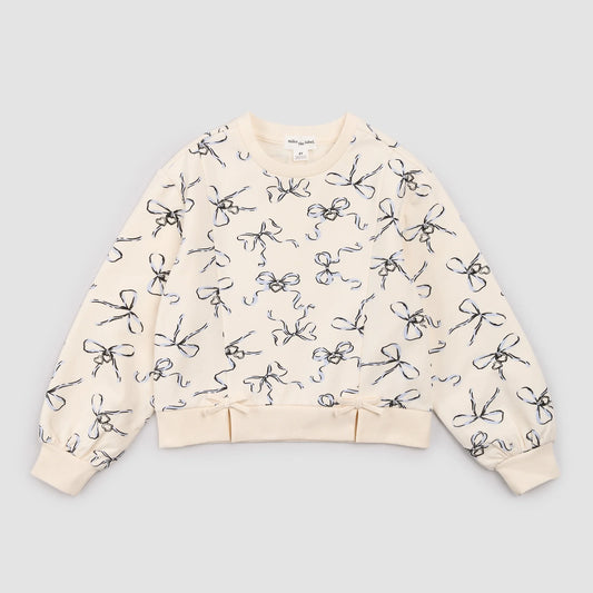 Ivory sweatshirt with bows and lockets by Miles the Label, featuring a cozy fit and decorative details in a close-up shot.