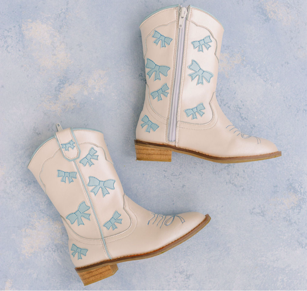 Cowgirl baby blue bow boots by Wild + Rae featuring stylish cowboy-style boots with bows, perfect for kids.