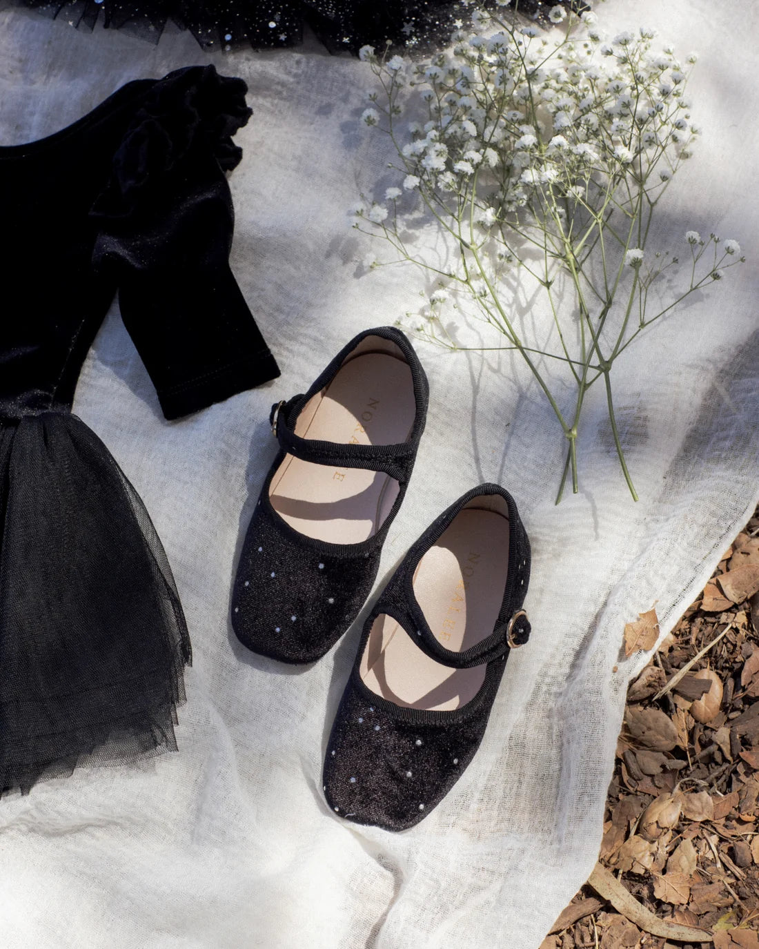 Black strap ballet flats by Noralee featuring a sleek design and comfortable fit, perfect for casual or dressy occasions.