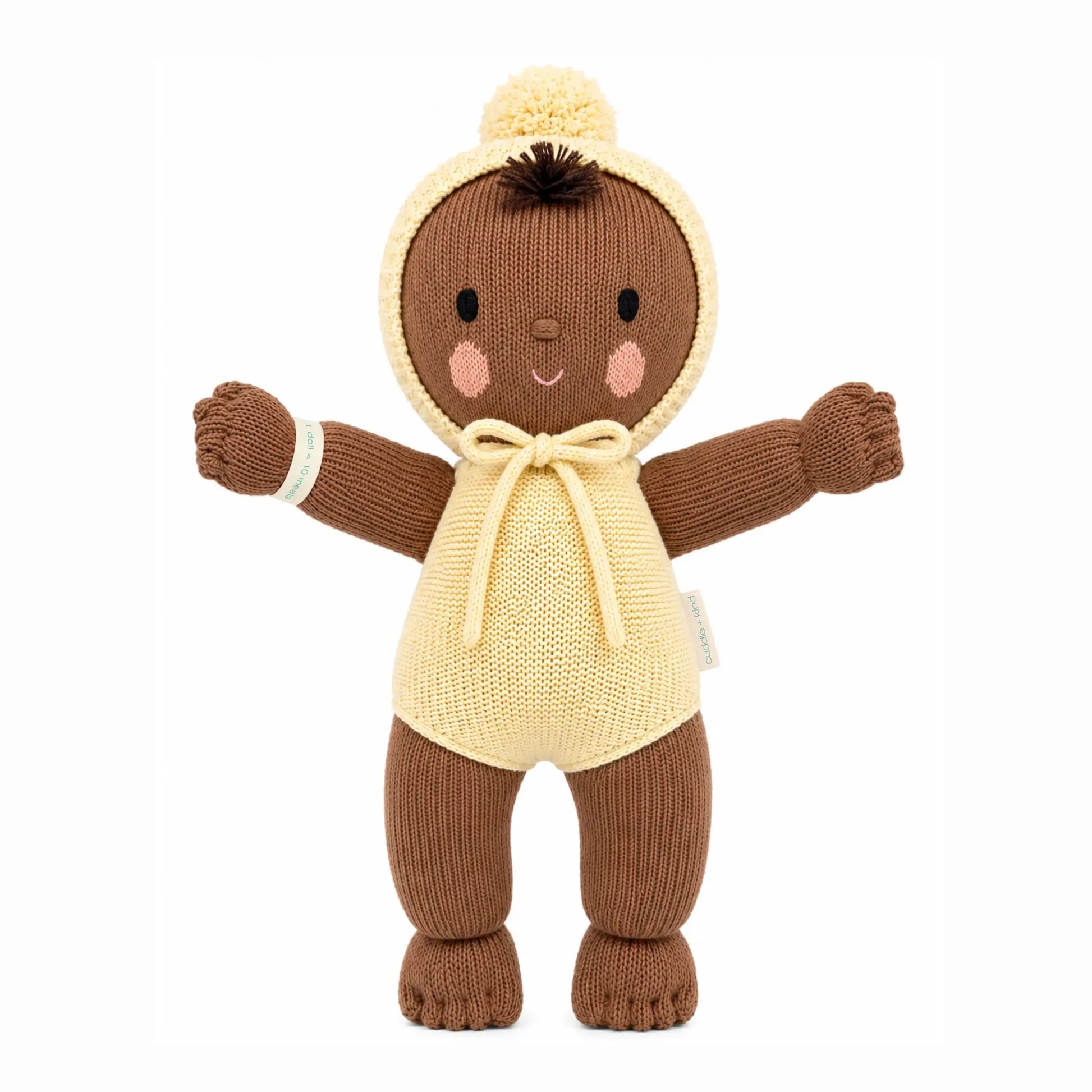 Soft plush My First Baby Buttercup doll by cuddle + kind with gentle facial features and pastel clothing.
