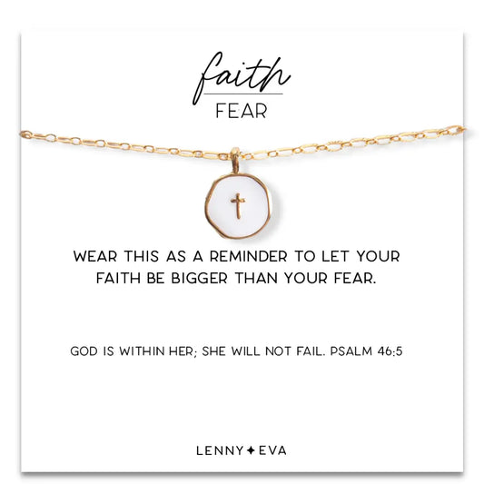 White enamel cross pendant with faith over fear design on gold chain, by Lenny & Eva, close-up view.