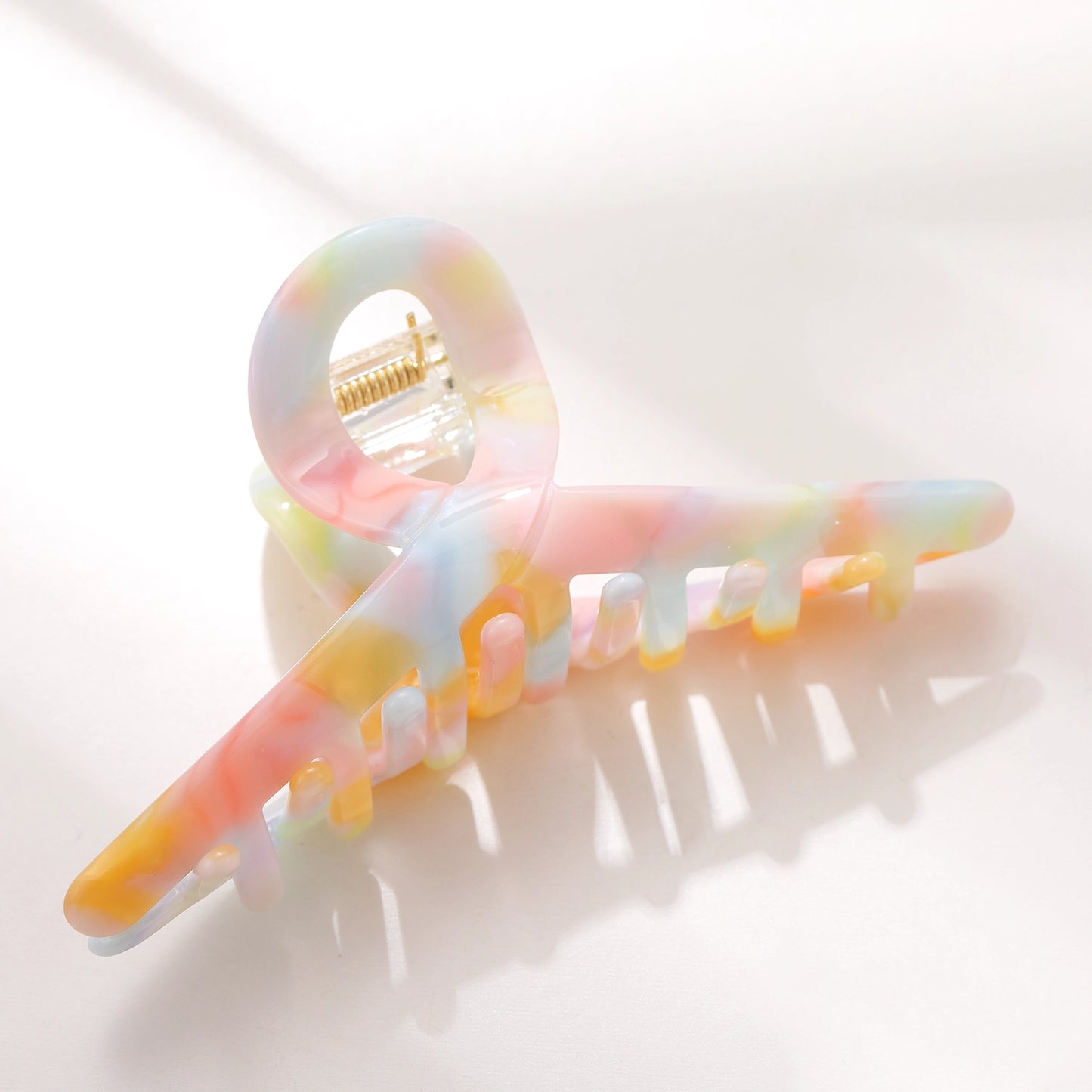 Pastel watercolor hair clip featuring soft pink, blue, and purple hues, ideal for children's hairstyles.