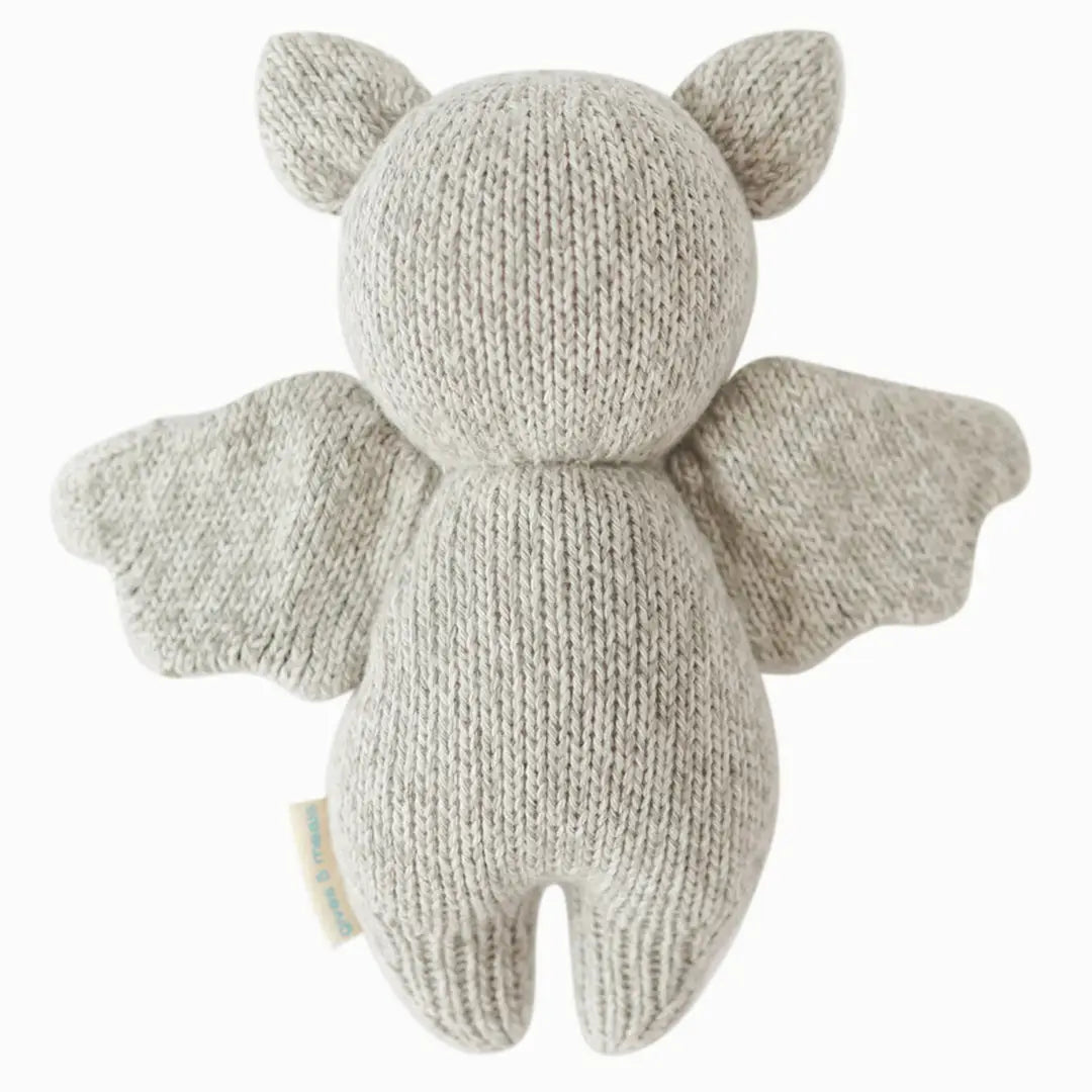 Grey baby bat plush toy by cuddle + kind, soft and cuddly stuffed animal for infants and toddlers, detailed bat shape and gentle features.