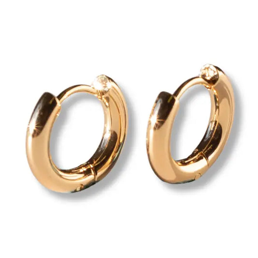 Lenny & Eva tarnish resistant gold hoop huggie earrings, close-up of shiny, small hoop earrings on a white background.