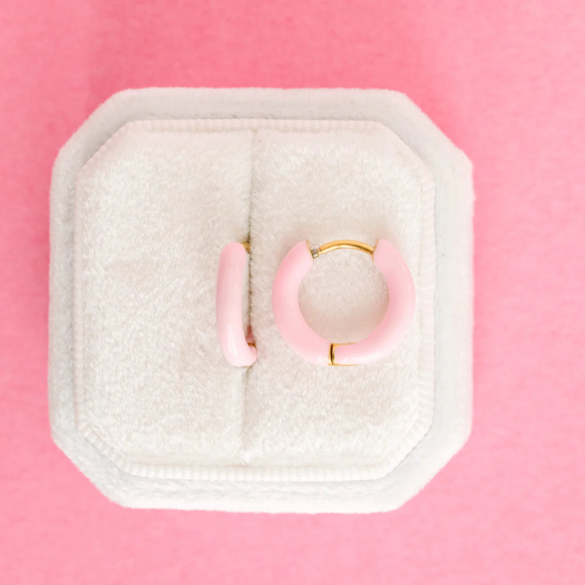 Colorful Pierced Co Huggies earrings featuring small, vibrant hoops for pierced ears on a white background.