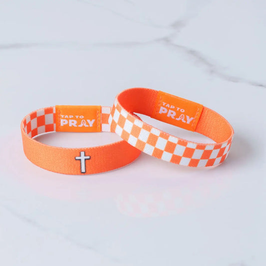 Versible Tap To Pray® wristband in orange and white checkers with religious symbols, made from durable fabric.