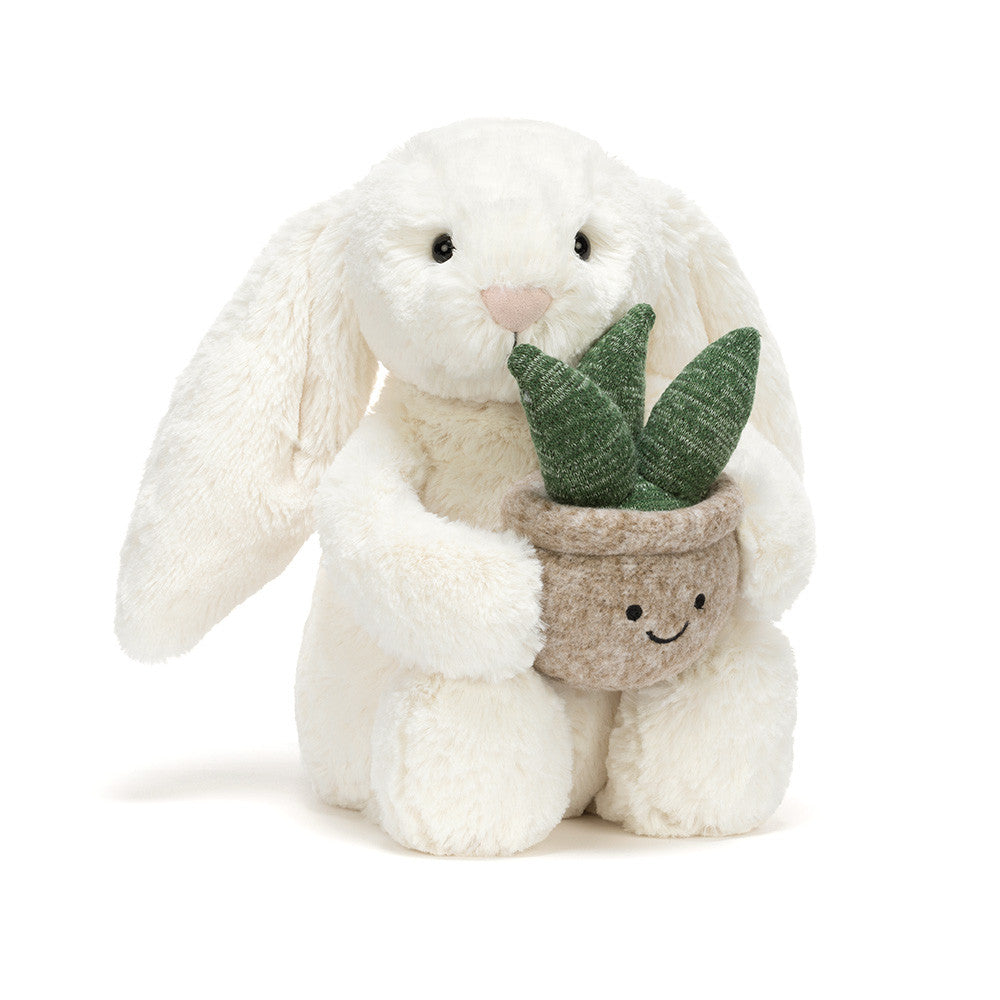 Jellycat Cream Bunny plush toy holding a small potted plant, soft and cuddly with floppy ears, ideal for children.