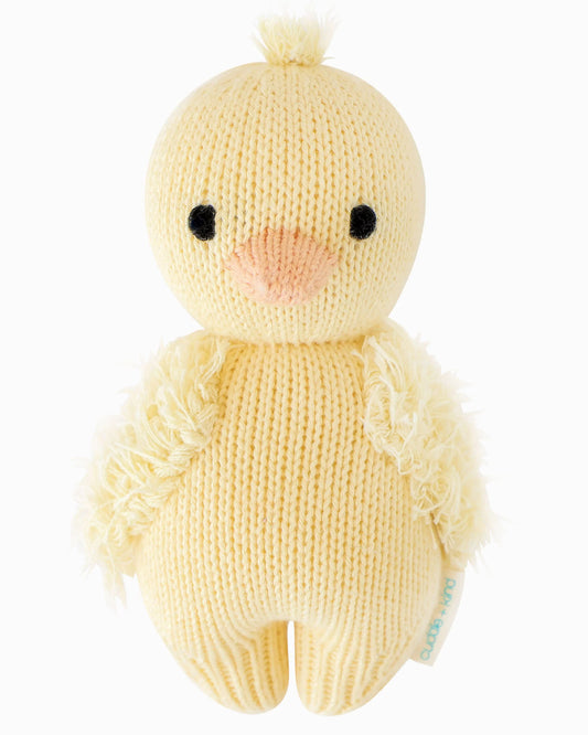 Cuddle + Kind baby duckling plush toy with soft yellow feathers and orange beak, showcasing adorable and cuddly design.