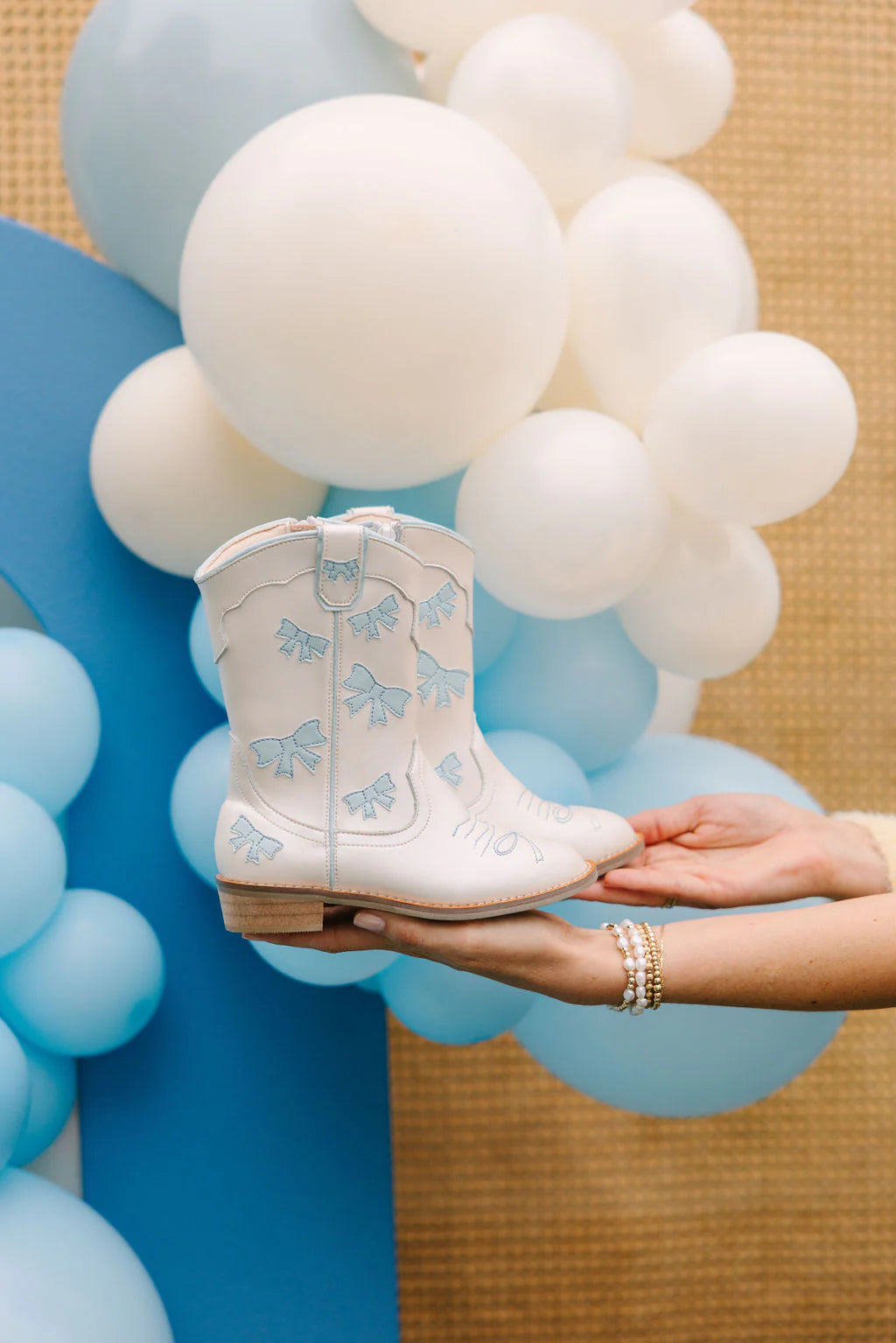 Wild + Rae cowgirl baby blue bow boots with decorative bows and stitching, stylish Western-inspired footwear for young children.