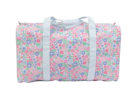 Ditsy floral duffle bag by Apple of My Isla with adjustable straps and spacious main compartment, shown on a plain background.