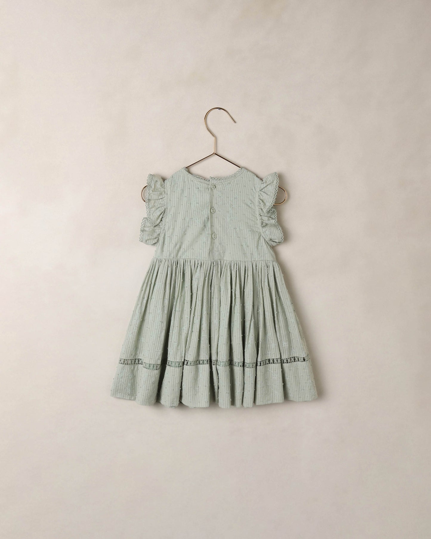 Eucalyptus Isla dress by Noralee featuring a flowy fabric and botanical print, displayed on a hanger against a neutral background.