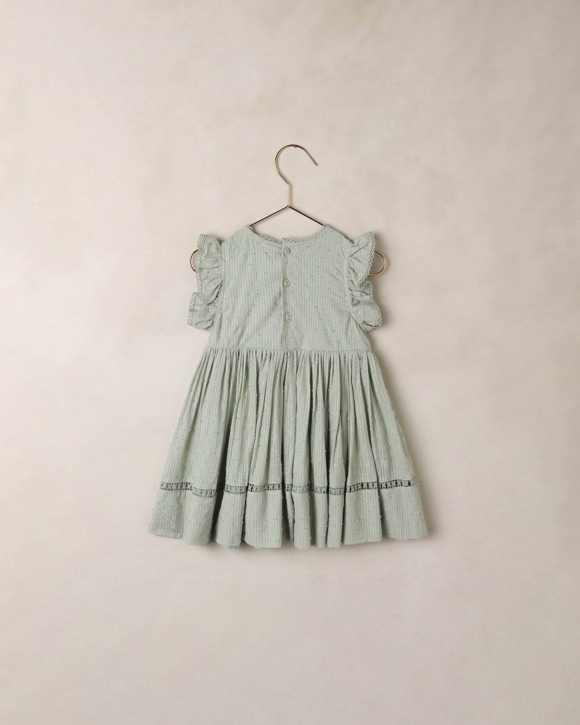 Eucalyptus Isla dress by Noralee featuring a flowy fabric and botanical print, displayed on a hanger against a neutral background.