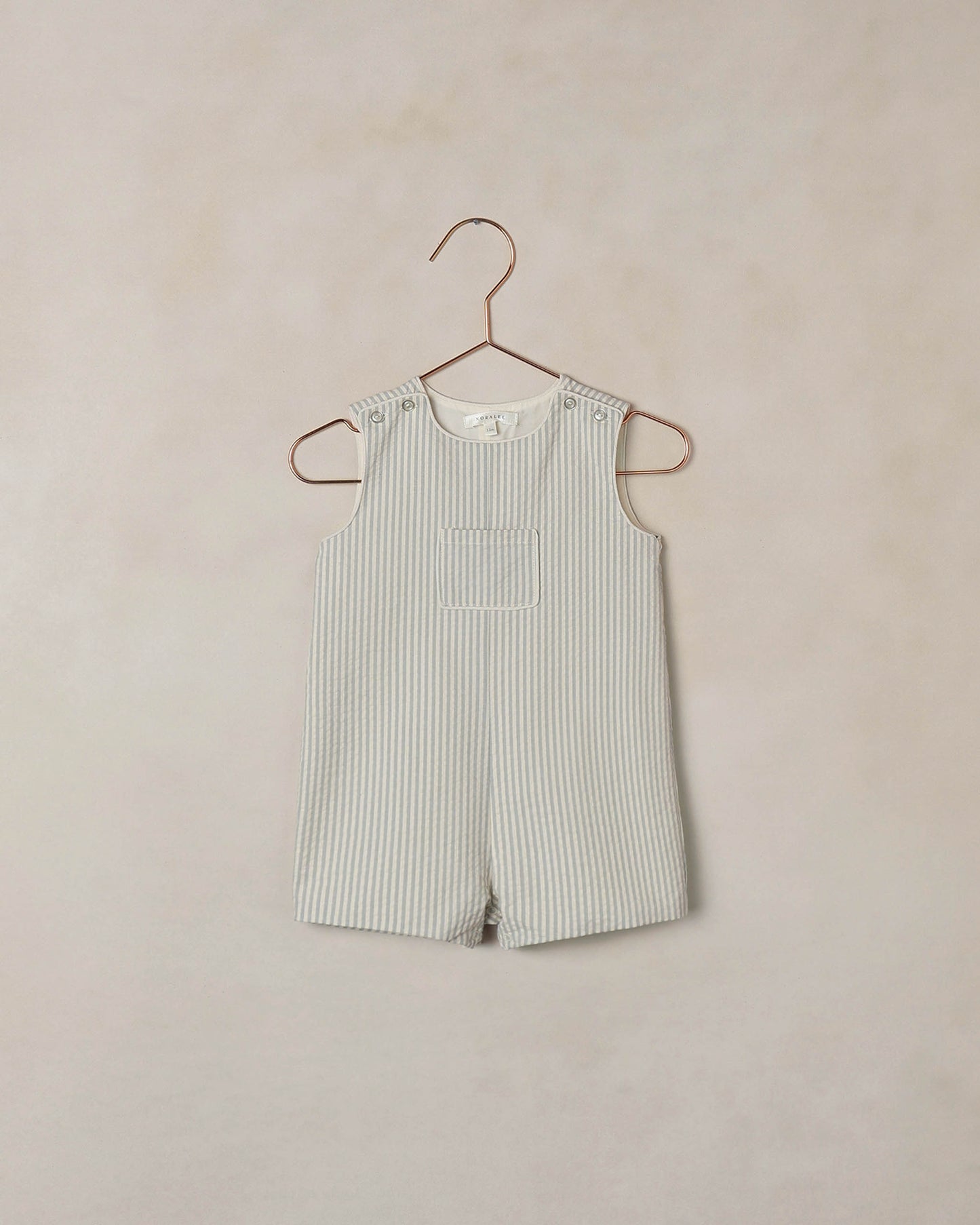 Noralee Sky Stripe Georgie Romper displayed on a mannequin, featuring colorful striped fabric and short sleeves for a playful, casual look.
