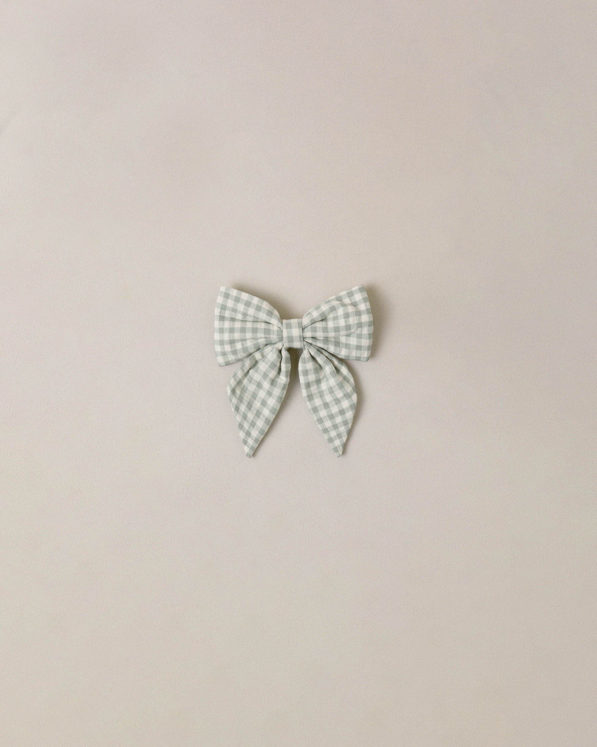 Noralee Eucalyptus Check Norah Bow, a stylish hair accessory featuring a green and white check pattern with a decorative bow.