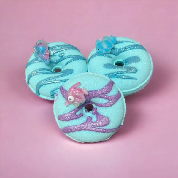 Ocean Breeze Donut Bath Bomb by The Lavish Goat, featuring a colorful donut-shaped bath bomb with ocean-inspired colors and textures.