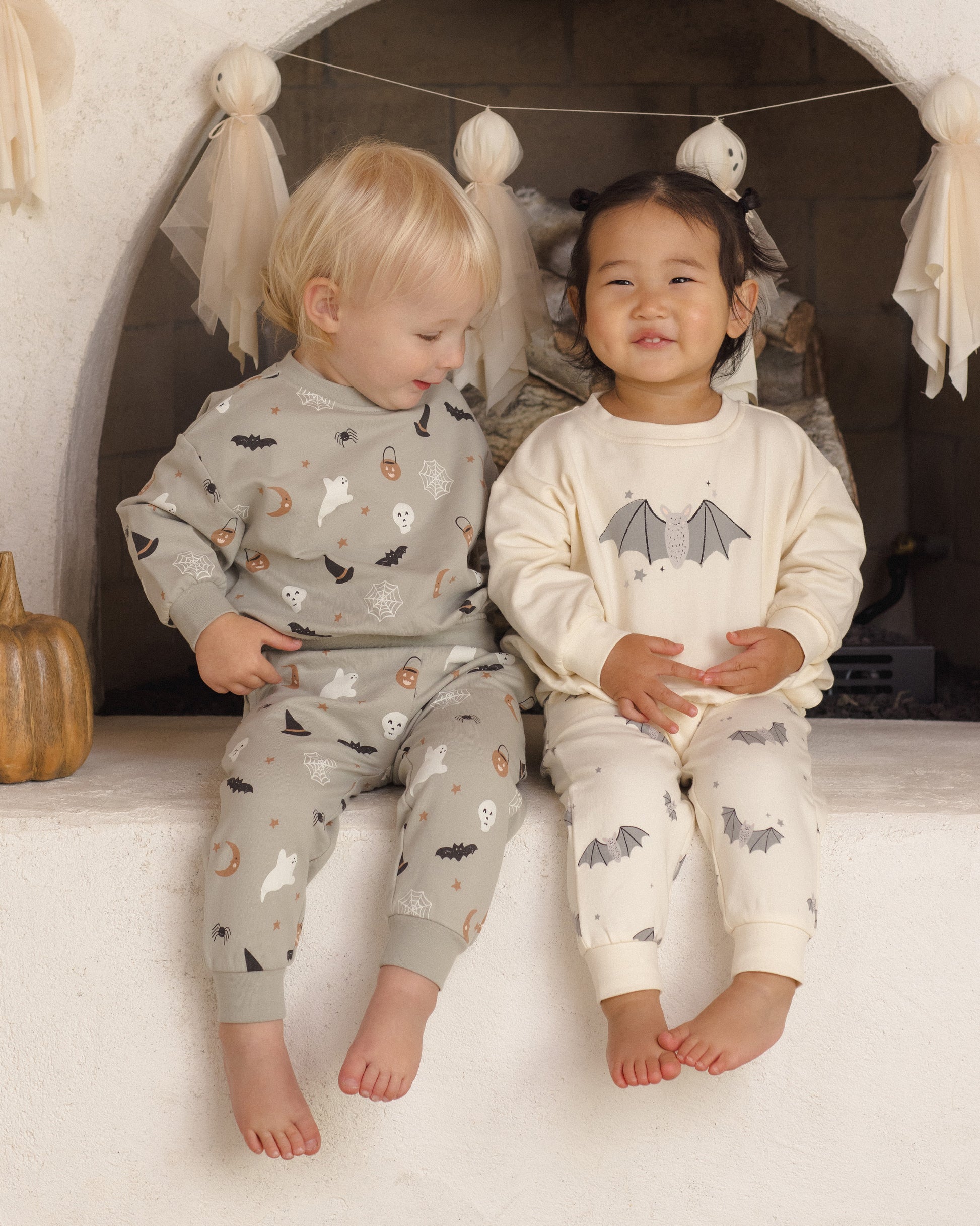 Baby girl wearing Quincy Mae Baby Bats Relaxed Fleece Sweatshirt, featuring a cute bat design, in a cozy lifestyle setting.