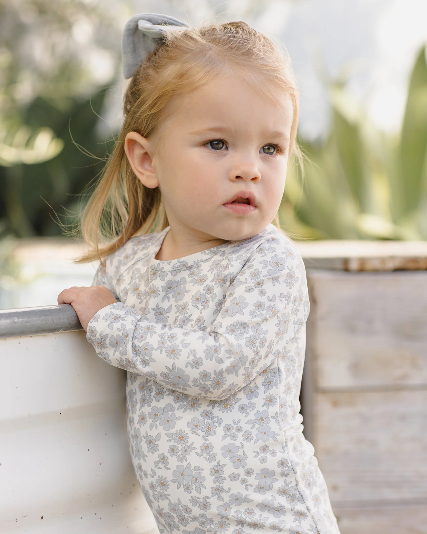 Blue floral Olivia rashguard one-piece swimsuit by Quincy Mae, featuring a vibrant floral pattern and long sleeves for sun protection.
