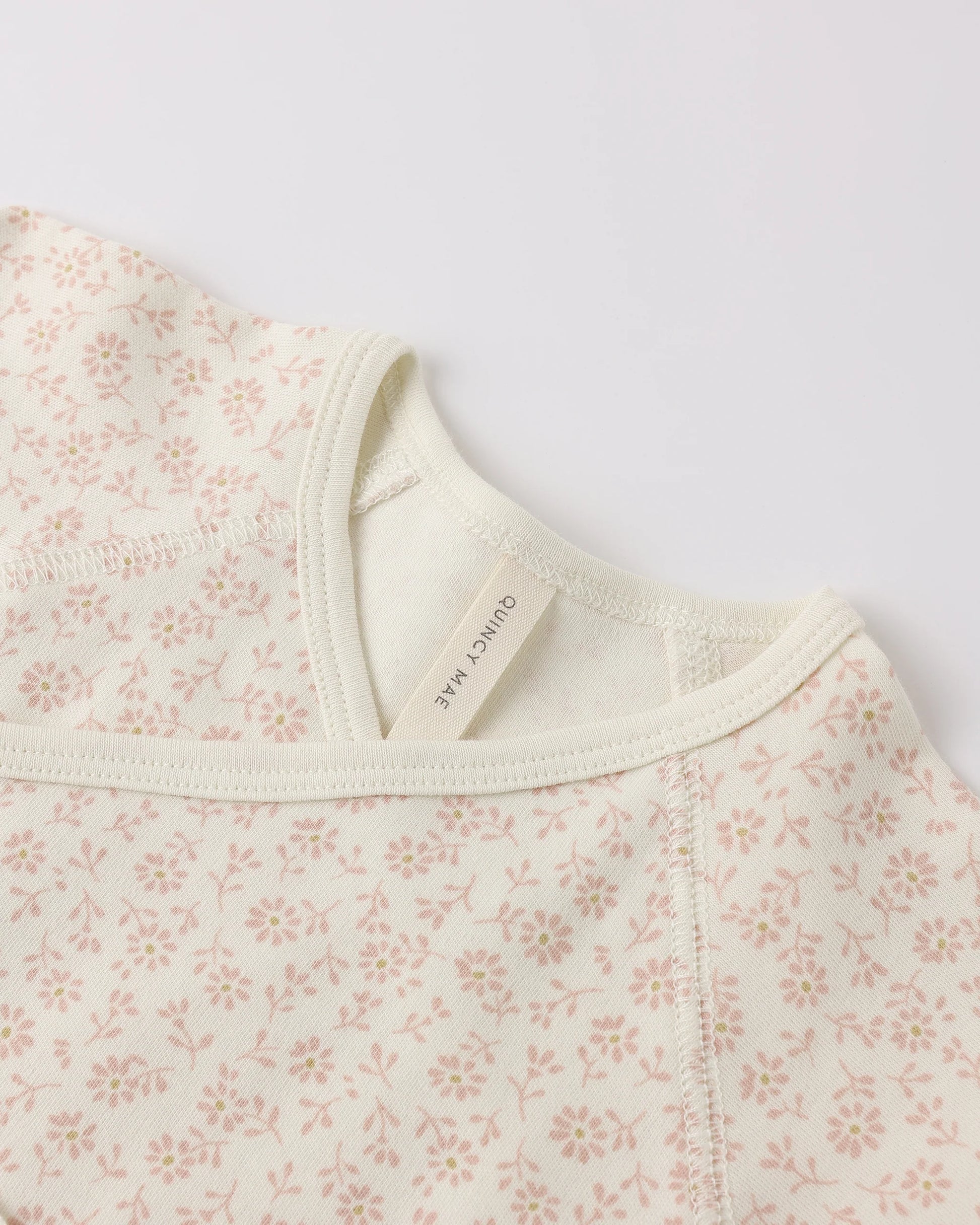 Quincy Mae Ditsy Wrap Top and Footed Pant set for babies, featuring a soft ivory fabric with delicate ditsy print and comfortable fit.
