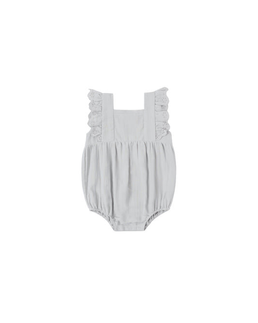 Sky Naomi romper by Quincy Mae, soft blue cotton one-piece with short sleeves and button closure, displayed on a hanger.