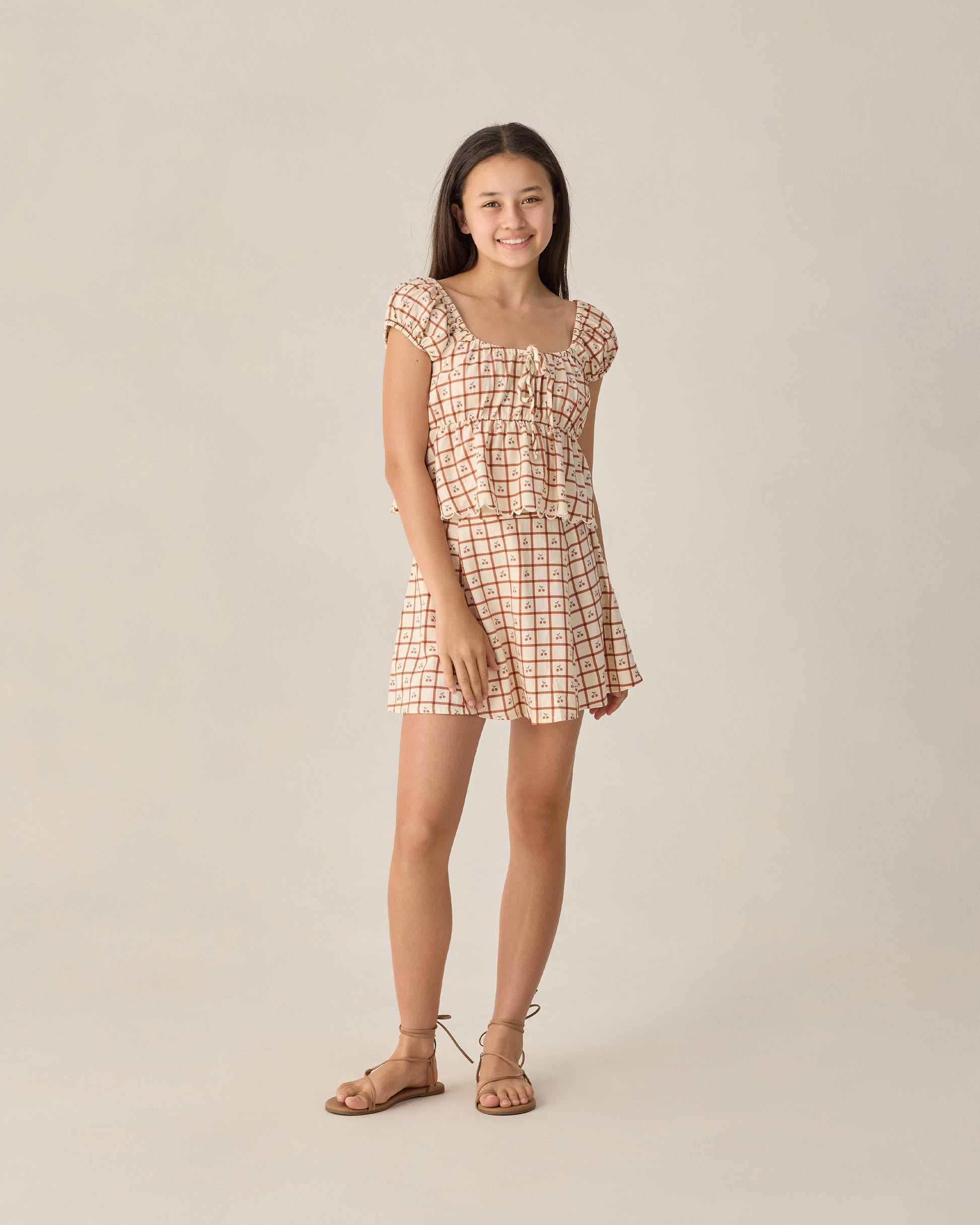 Teen Cherry Check Rylan Top by Rylee & Cru, featuring a cherry plaid pattern and relaxed fit, shown on a young girl.