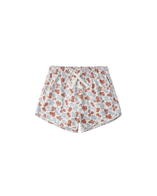 Rylee & Cru Americana floral swim trunks with a natural background, featuring vibrant floral patterns and adjustable waistband.