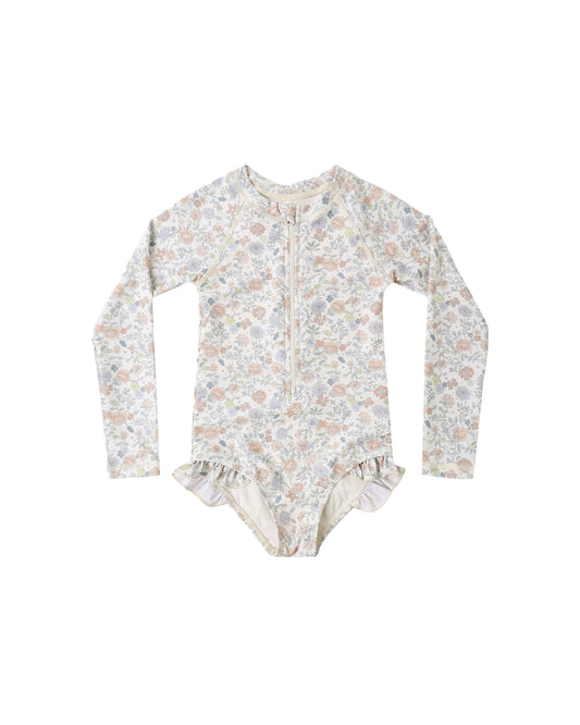 Rylee & Cru Bloom Rashguard One Piece in ivory, featuring a floral design and long sleeves for sun protection.