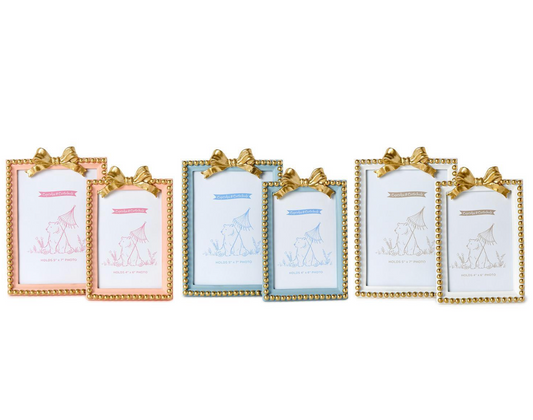 Two golden bow photo frames from Twos Company, decorative frames with elegant bow accents for photos or displays.
