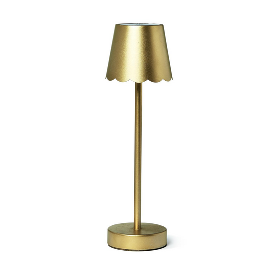 Two's Company gold LED cordless table lamp with scalloped edge shade and modern design, illuminated on a table.