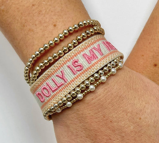Adjustable woven bracelet with "Dolly Is My Hero" text by SOUTHERN FRIED DESIGN BARN, featuring colorful woven design and metal clasp.