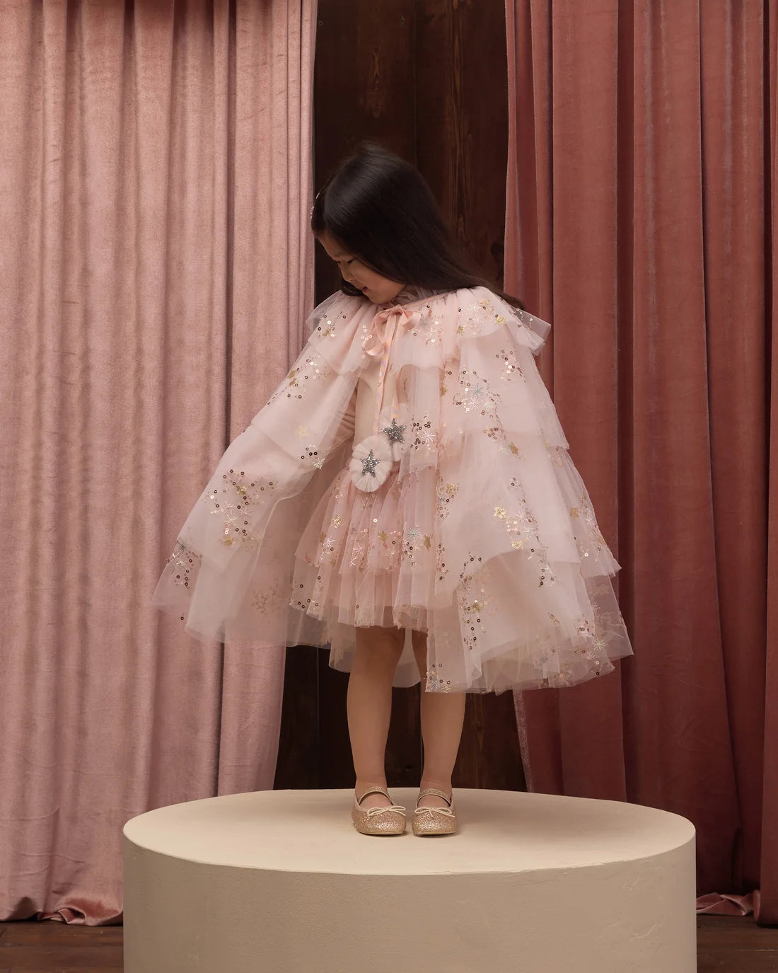 Pink tulle cape by Noralee, featuring delicate layers of soft, airy tulle fabric with a flowy, elegant design.