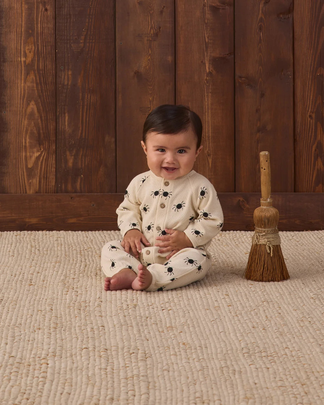 Quincy Mae Bitsy Spider Waffle long sleeve jumpsuit for babies, soft beige fabric with playful spider pattern and cozy fit.
