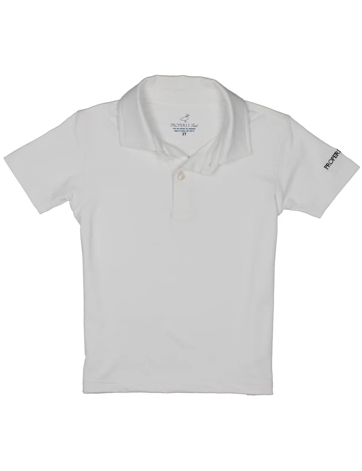 Boy wearing a white Academy polo shirt by Properly Tied, front view showing collar and button placket.