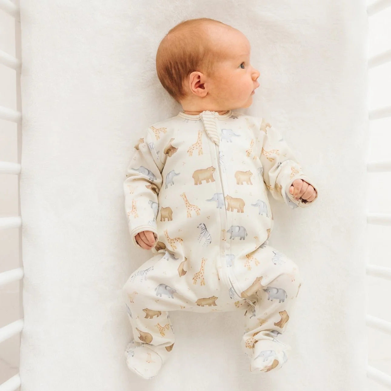 Luna + Arlo Safari Zip Footie for babies, soft fabric with zipper closure, featuring safari animal print and cozy design.