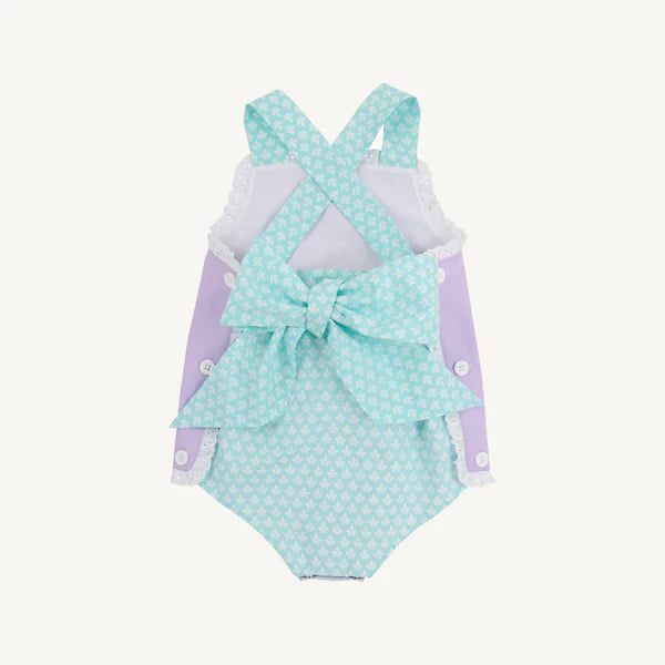 Baby girl wearing Lauderdale Lavender Sisi Sunsuit with Dunmore Doo-Dad by The Beaufort Bonnet Company, back view showing cute design.