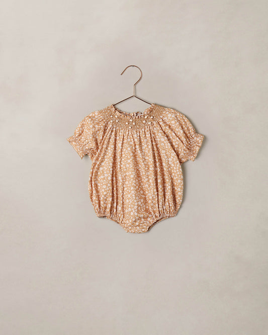 Noralee Golden Meadow Maddie Romper displayed on a hanger, featuring a floral pattern and soft fabric ideal for warm weather.
