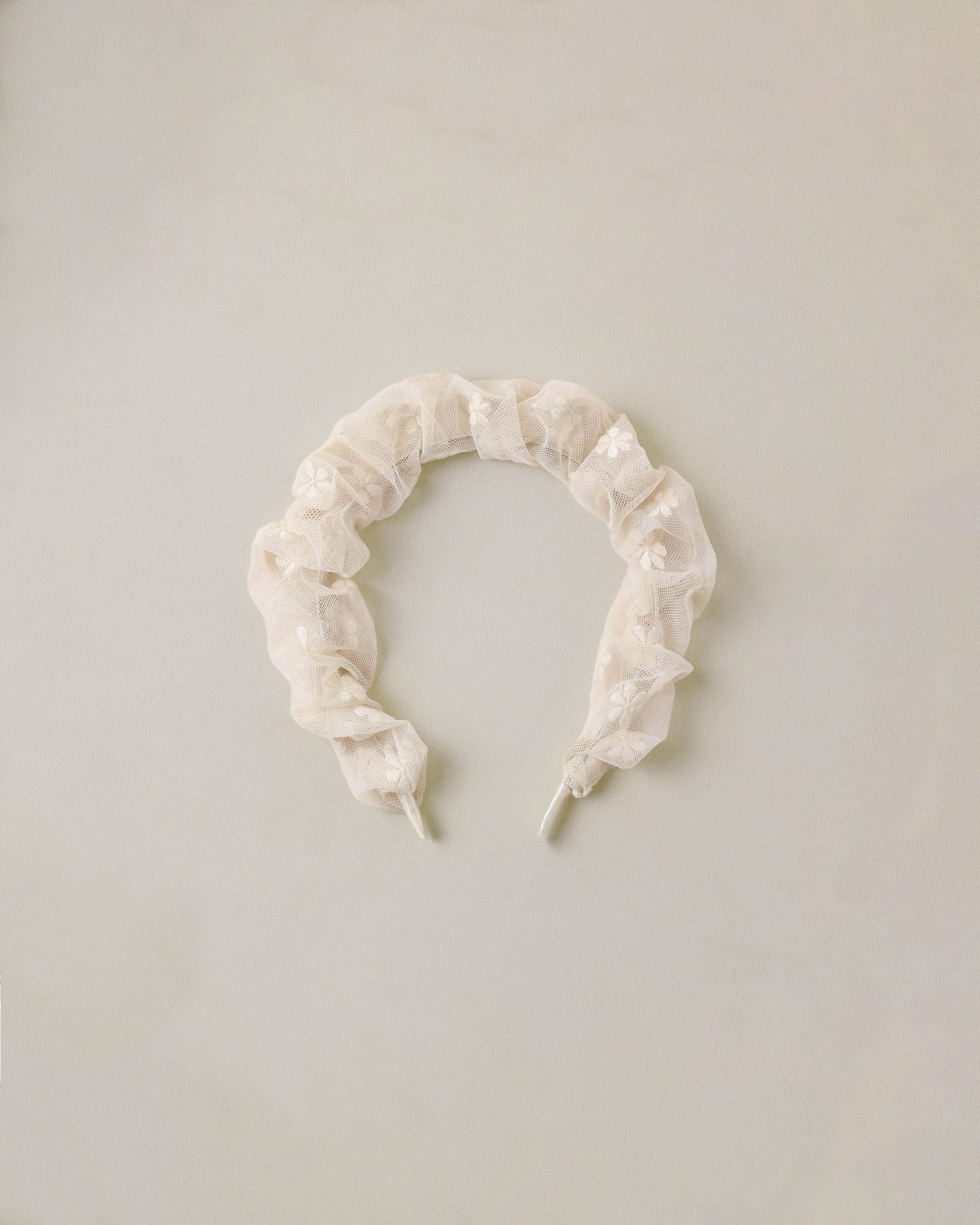 Noralee embroidered daisy gathered headband with floral design, featuring intricate embroidery and soft fabric for a stylish accessory.